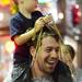 Jon Fogel, of Tampa, laughs as he son Jack, 2, decorates his with beads during the Outback Bowl New Year's eve parade in Ybor City, Fla. on Monday night. Melanie Maxwell I AnnArbor.com